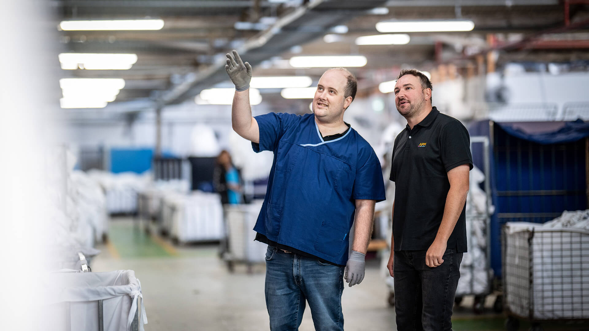 Inclusive employment in action with a worker with disability talking about his job to an APM consultant